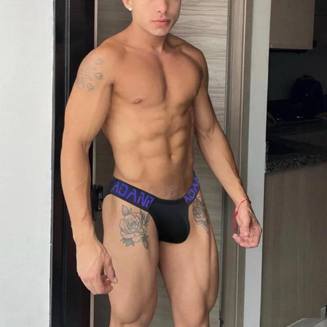 Black Adannu low-waist hip briefs with purple waistband, designed for comfort and style, modeled in a standing pose.