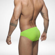 Back view of men's neon green swim briefs showcasing a snug fit and durable fabric, ideal for beach and pool activities.