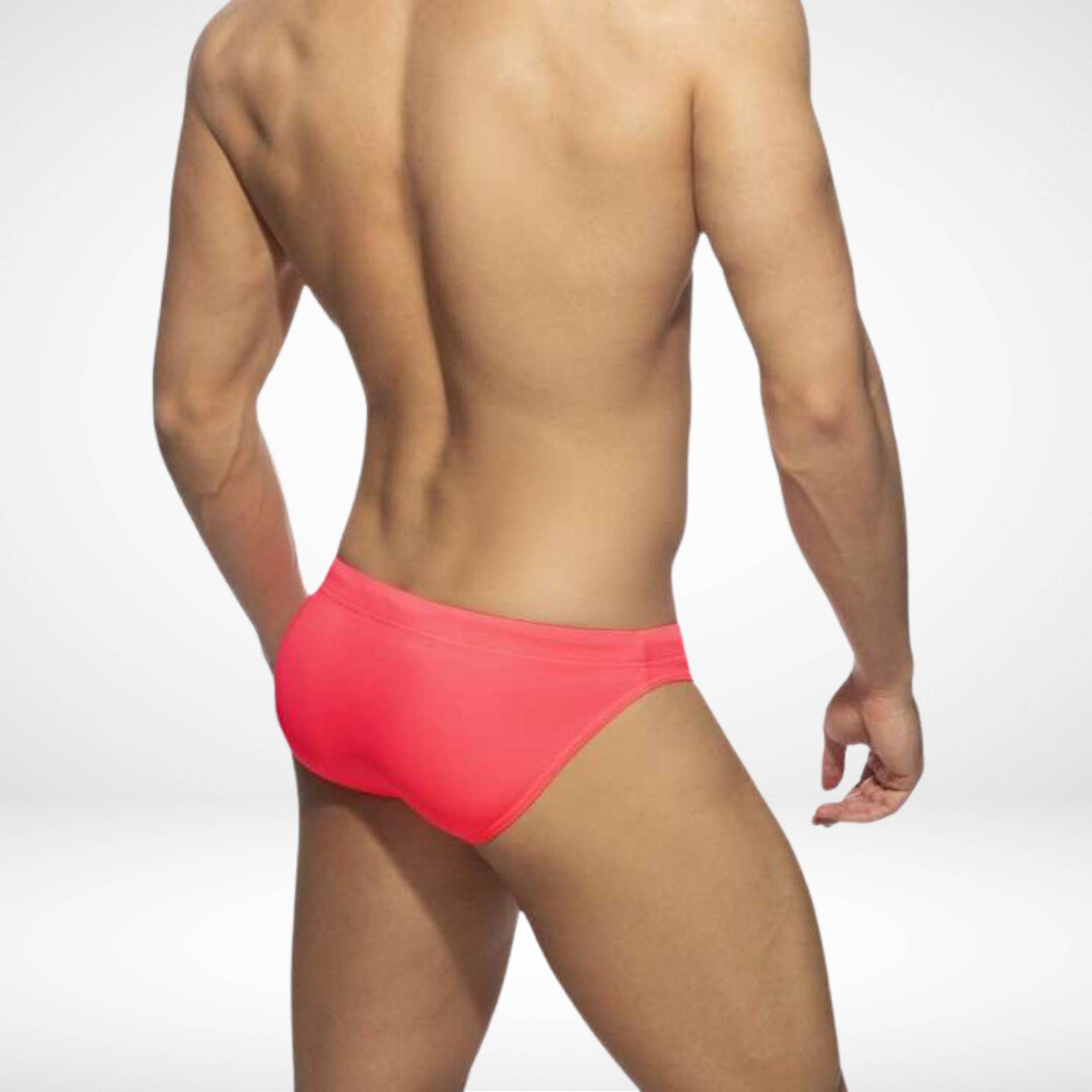 Back view of men's pink swim briefs highlighting a snug fit and durable fabric, ideal for beach and pool activities.