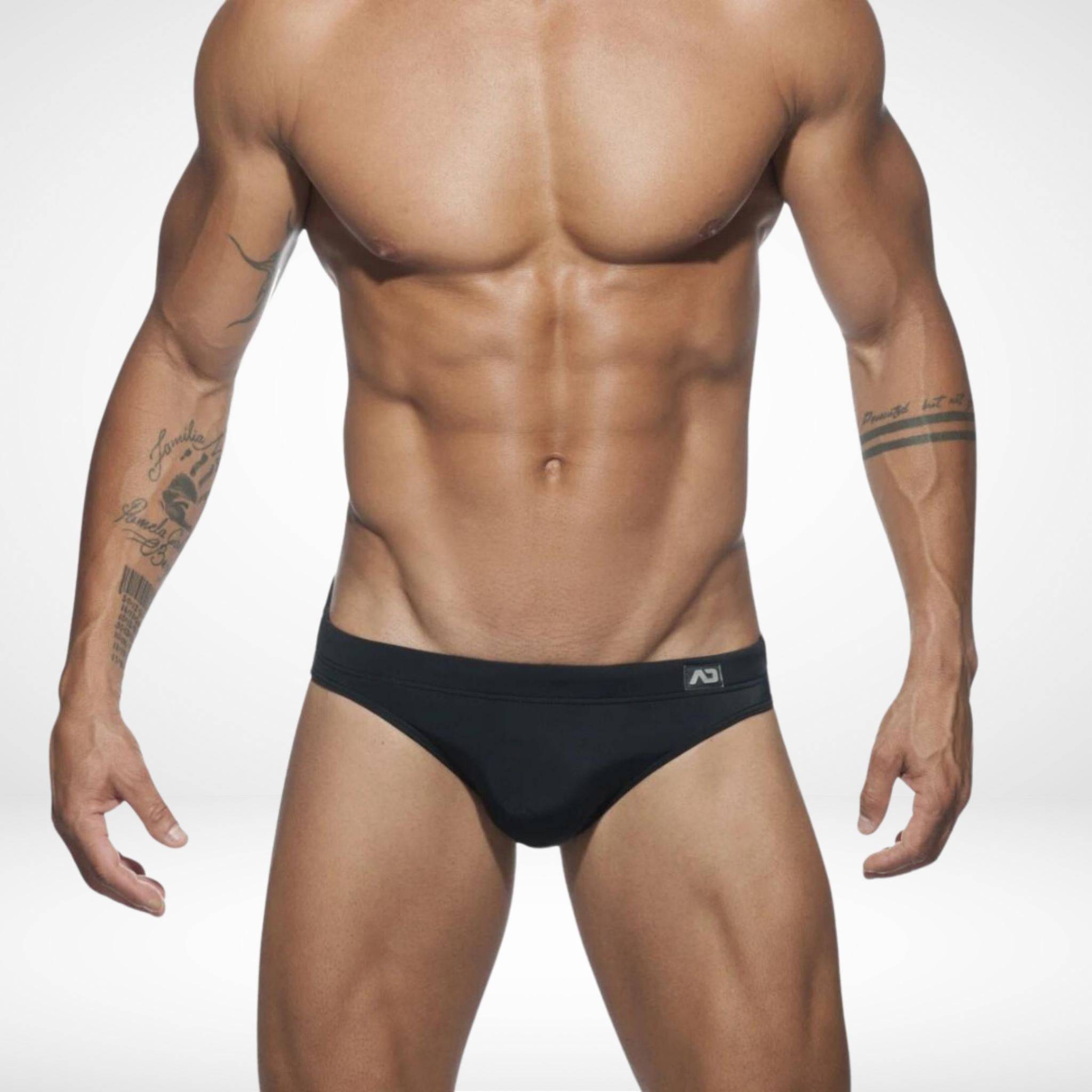 Men's black quick-dry swim briefs with a minimalist design, offering a secure fit and removable pad for versatile swimwear.