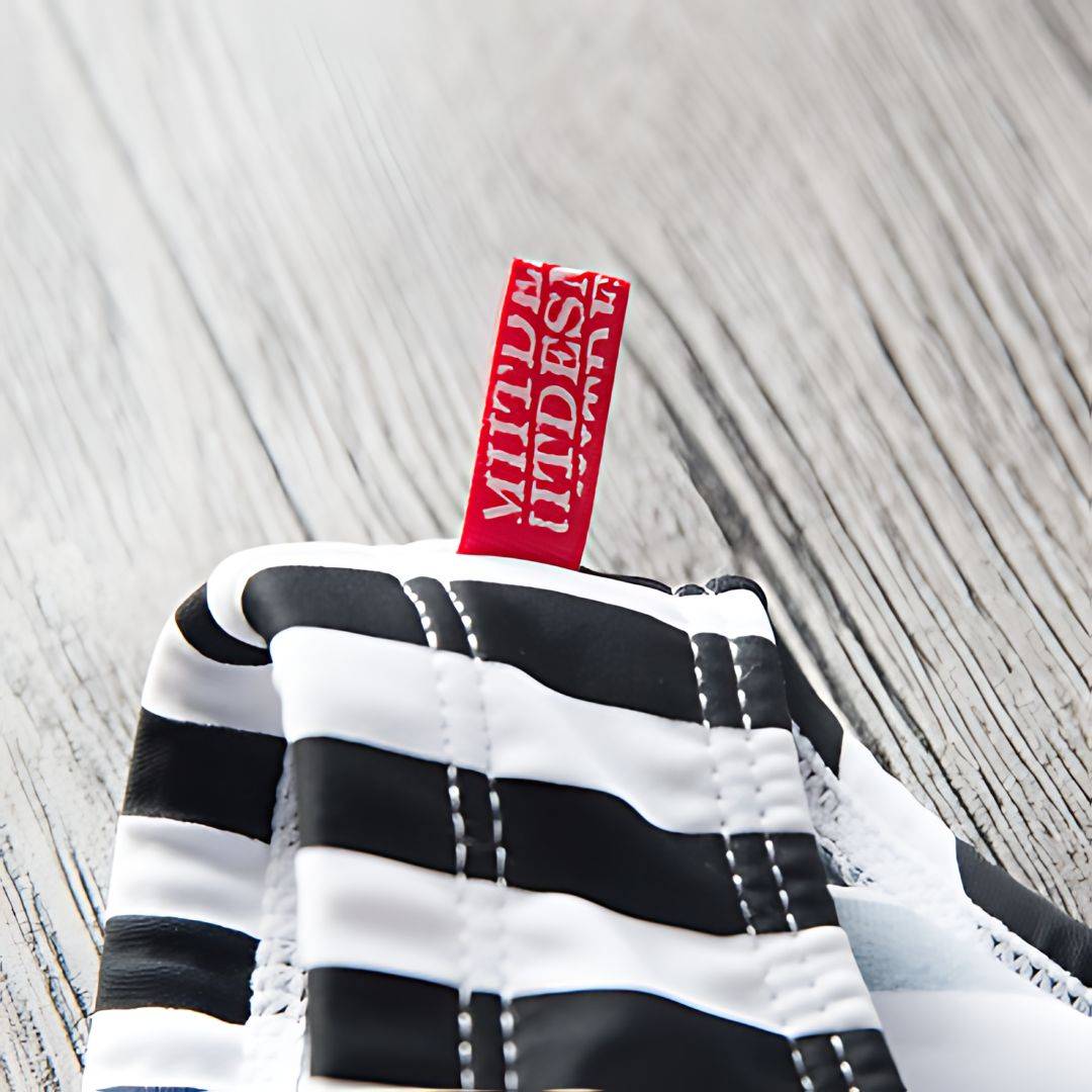 Close-up of the red tag detail on Black & White Vertical Stripe Swim Briefs, highlighting the brand design.