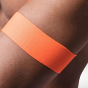 Close-up of orange matching arm band from the neon circuit party harness set, highlighting its smooth texture and vibrant color.