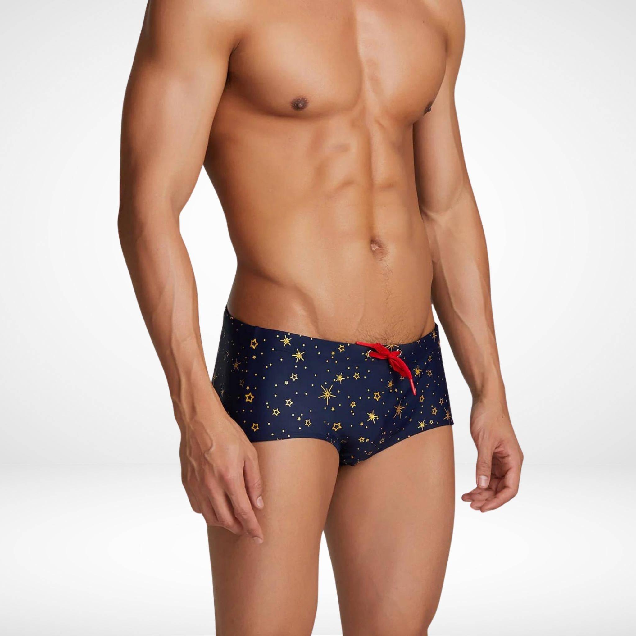 Fitted men's gold star swim trunks with quick-dry nylon-spandex blend, showcasing a vibrant star design and red drawstring in a side view.