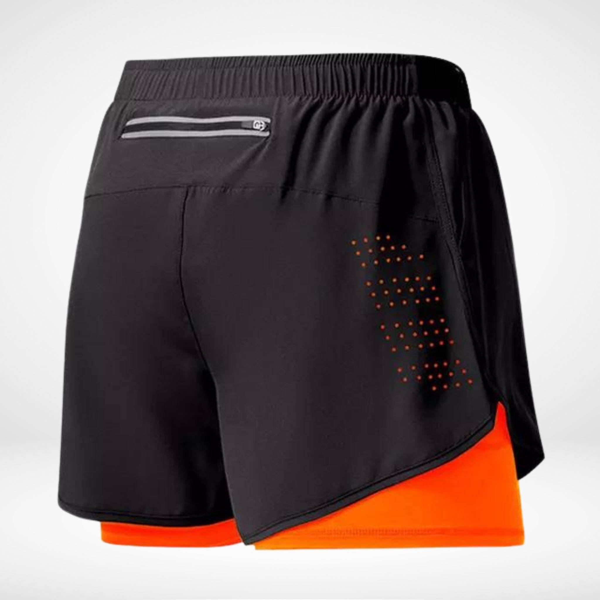 Black METCON workout shorts with orange liner, zippered back pocket, and laser-cut ventilation, perfect for gym and training sessions.