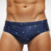 Close-up of navy blue swim briefs with colorful palm tree print, highlighting the durable and stretchy fabric for men's swimwear.