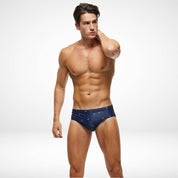 Front view of men's palm tree swim briefs in navy blue, designed with a stretchy, quick-dry fabric for active beach or pool wear.