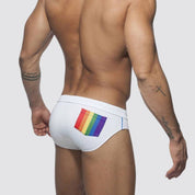 Back view of white swim briefs featuring a vibrant rainbow pocket and a low-rise design for men.