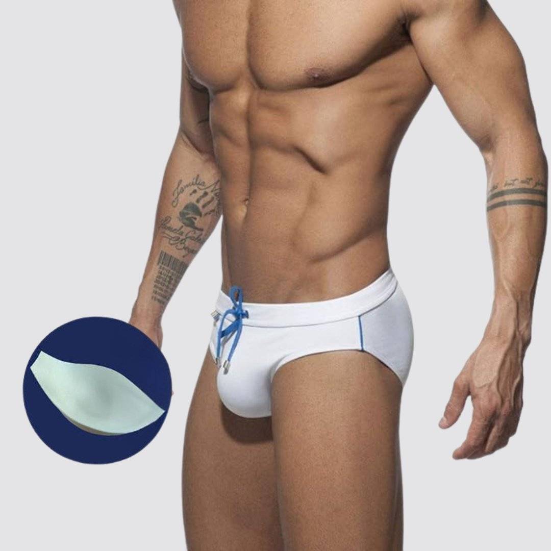 White swim briefs with optional enhancement pad, blue drawstring, and rainbow detailing for added style.