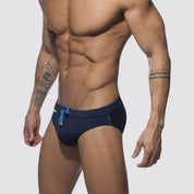 Men's navy swim briefs with blue drawstring and rainbow detailing, offering a comfortable and stylish fit.