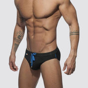 Men's black swim briefs with blue drawstring and rainbow detailing, offering a sleek and modern fit.