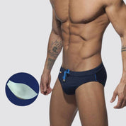 Navy swim briefs with optional enhancement pad, blue drawstring, and rainbow detailing for a bold look.