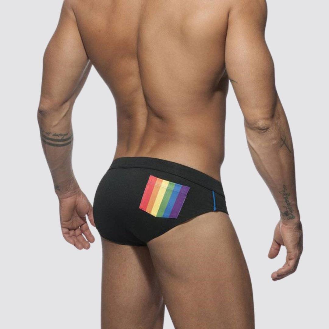 Back view of black swim briefs featuring a vibrant rainbow pocket and a low-rise design for men.