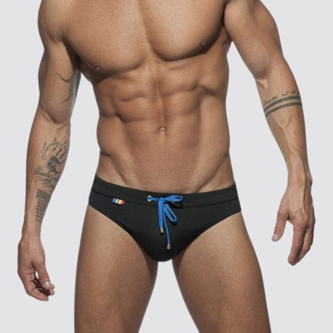 Front view of black swim briefs with blue drawstring and rainbow detailing, designed for quick-dry performance.