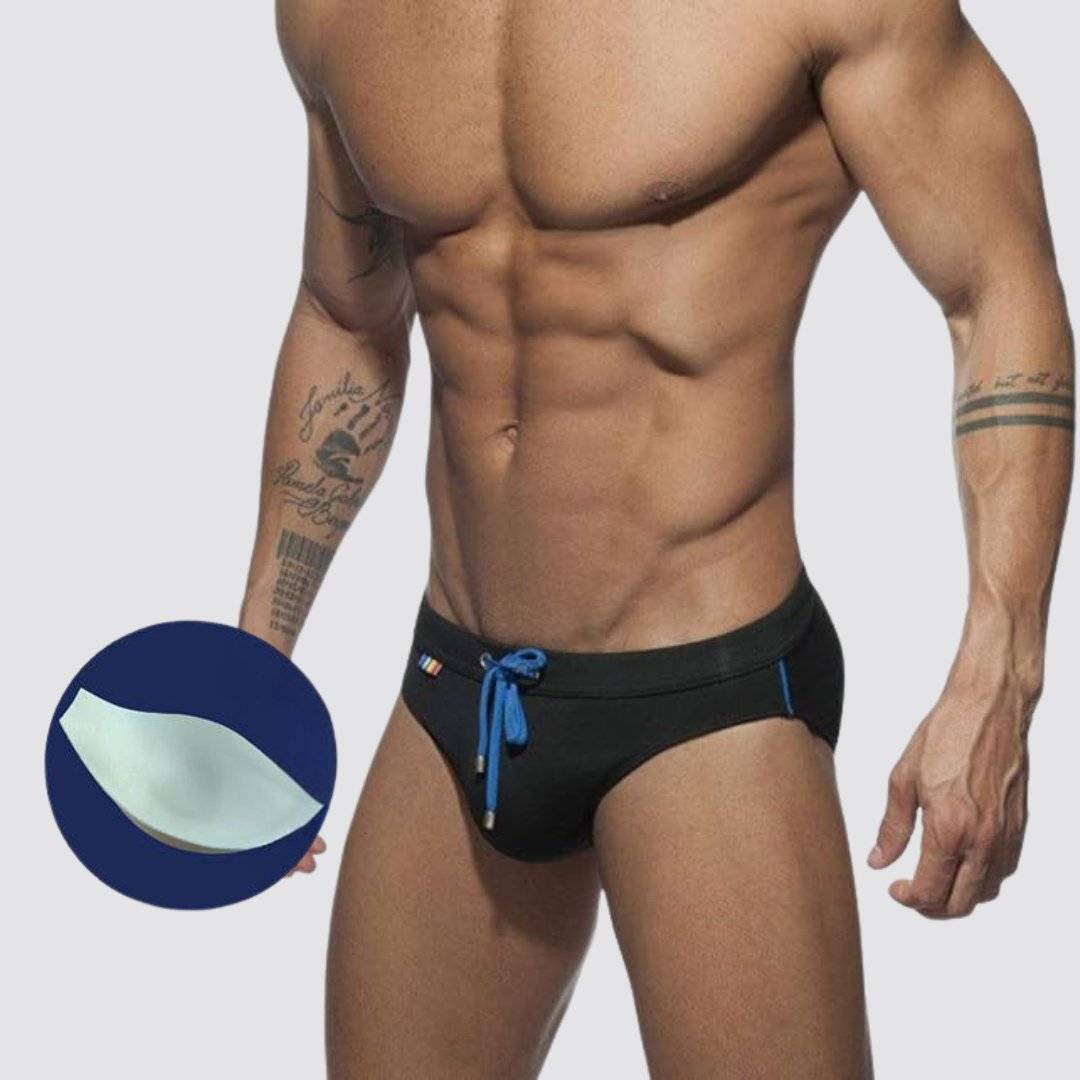 Black swim briefs with optional enhancement pad, blue drawstring, and rainbow detailing for added style.