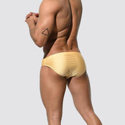 Men's shimmer low rise swim briefs in gold, back view highlighting snug fit and smooth fabric ideal for pool or beach wear.