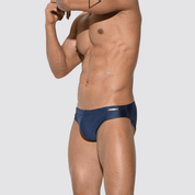 Men's shimmer low rise swim briefs in navy blue, side view with adjustable drawstring and form-fitting nylon-spandex fabric.