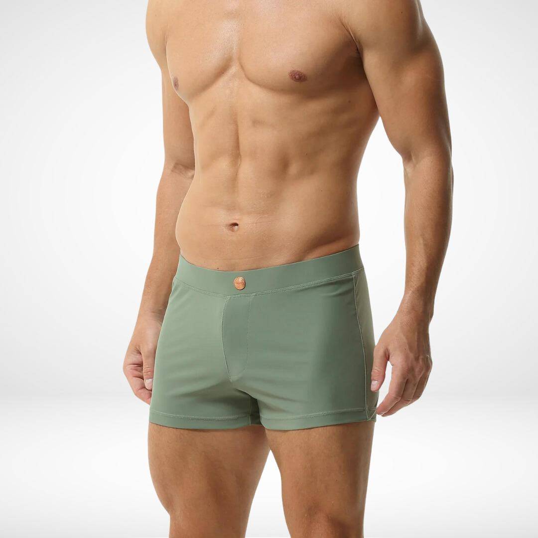 Side view of men's green square cut swim trunks, emphasizing the sleek fit and smooth fabric for a modern swimwear look.