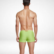 Back view of men's lime green square cut swim trunks, highlighting the smooth and streamlined design for a modern swimwear style.