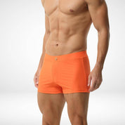 Side view of men's orange square cut swim trunks, emphasizing the sleek fit and smooth fabric for a modern swimwear look.