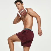 Maroon men's lined gym training shorts with a Tauwell branded waistband, shown in motion for athletic performance and comfort.