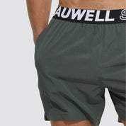 Close-up of green men's lined gym training shorts with a Tauwell branded waistband, emphasizing the lightweight and moisture-wicking fabric.