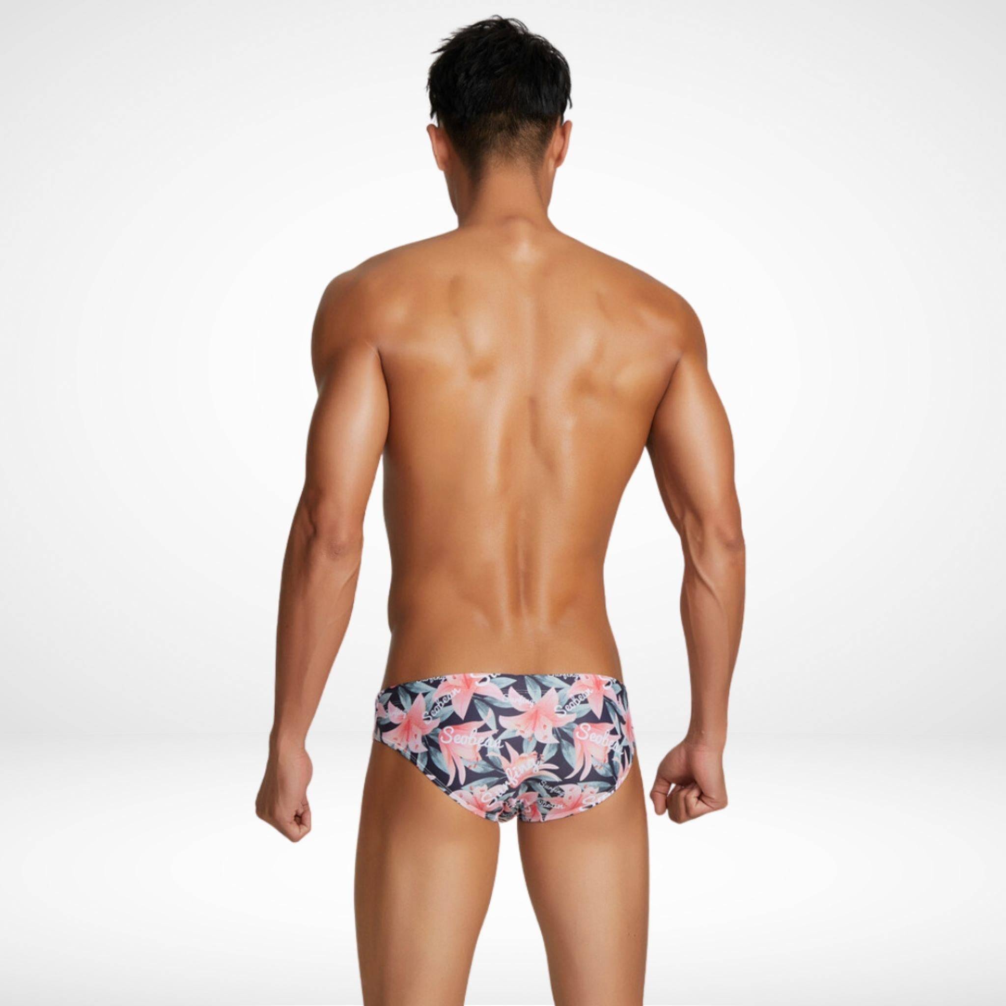 Back view of Men's Water Lily Swim Briefs in a dark floral pattern, showcasing a sleek and comfortable fit for swimming or sunbathing.