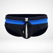 Close-up of black and blue zipper front swim briefs with a white zipper and drawstring, highlighting the modern design.