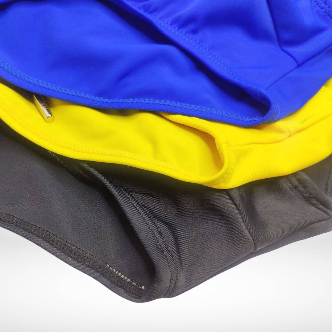 Close-up of yellow, blue, and black swim briefs, emphasizing the bold colors and durable fabric for swimwear.